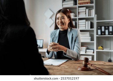 Dedicated lawyer of asian descent engages in a thoughtful discussion with a client in a cozy office setting, exuding professionalism and trust - Powered by Shutterstock