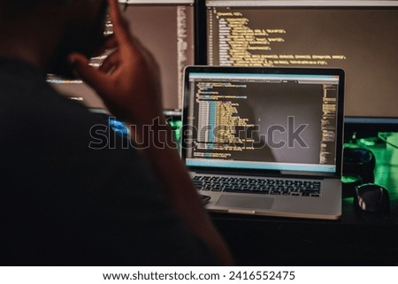 Dedicated Programmer Burning the Midnight Oil in a Dimly Lit Office, Surrounded by Multiple Screens and Tackling Complex Coding Projects