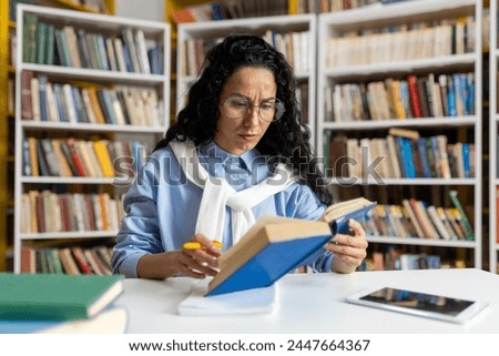 A dedicated student engrossed in reading a book surrounded by a vast collection of literature in a well-stocked library.