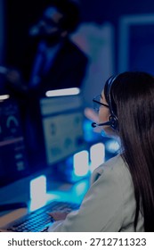 Dedicated support agent headset active listens intently customer issue screen shows account data CRM system late night resolving problems providing excellent service customer first focus now help.