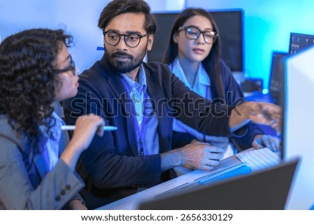 A dedicated IT team collaborates in a command center, working on a critical software deployment or incident response. Concept for system implementation, teamwork, and operations.