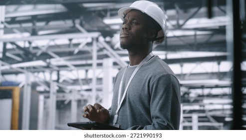 Dedicated Technician Concerned Expression While Holding Tablet, Suggesting Troubleshooting Industrial Alert or Issue in Large, Modern Machinery of Plant. Problem solving and Operational Intensity.