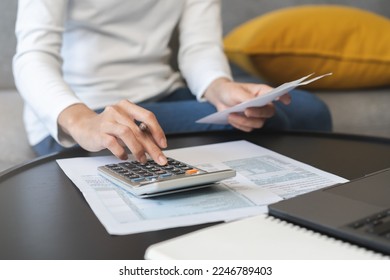 Deduction planning concept. Asian young woman hand using calculator to calculating balance prepare tax reduction income, cost budget expenses for pay money form personal Individual Income Tax Return.