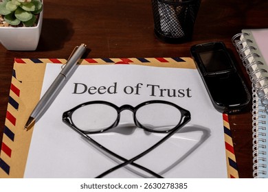 Deed of Trust Document on Envelope with Pen and Eyeglasses Represents Legal Security in Property Financing and Ownership