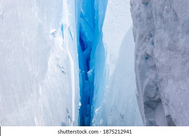 Deep Blue Crack In A Glacier In Antarctica. Close-up. A Break In The Glacier. Global Warming.