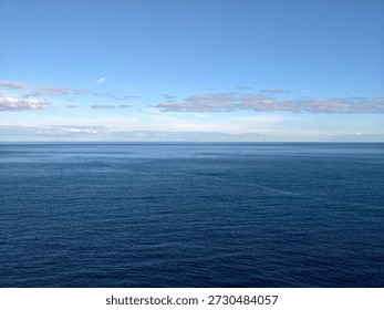 Deep blue ocean toward distant horizon, broad water field with subtle ripples and clear sky, meditative mood