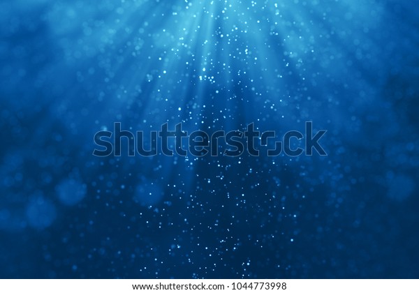 水中の背景に深い青い海の波と パーティクルが流れ 光が通り抜ける の写真素材 今すぐ編集