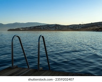 Deep blue water around pier or dock with metal handrail. Swimming, jumping into sea or ocean, diving or snorkeling concept. . High quality photo - Powered by Shutterstock
