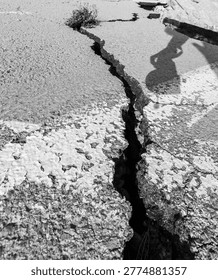 Deep crack in dry ground surface. Concept of drought, climate change and environmental damage.