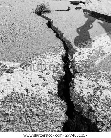 Deep crack in dry ground surface. Concept of drought, climate change and environmental damage.