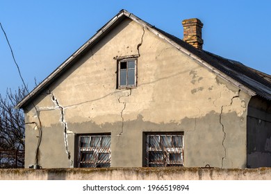 Deep cracks in facade of house. Sample of low-quality work. Topic: errors in construction of walls and foundations, destruction.