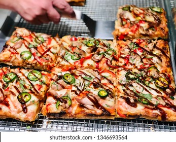 Deep Dish Pizza Slices In Square Style With Sign At Pizzeria And Serving Spatula