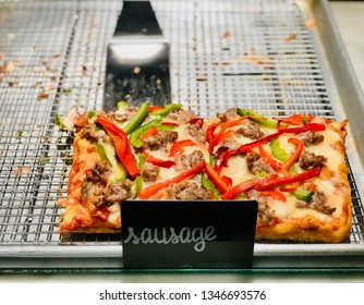 Deep Dish Sausage Pizza Slices In Square Style With Sign At Pizzeria And Serving Spatula