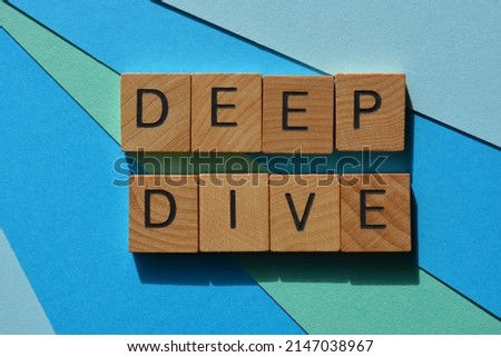 Deep Dive, words in wooden alphabet letters isolated on blue background