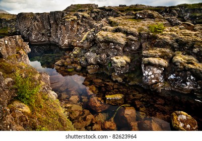 Deep Fissure Flosagja With Crystal Clear Cold Water At Thingvellir National Park. The Fissure In The Earth's Crust Where The European And American Continental Plates Drift Apart.