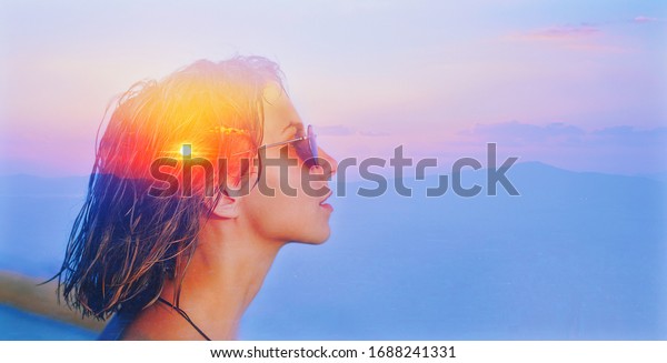 Deep fresh air calm peace life, teen girl dream, soul\
body concept. Double exposure portrait of a cute happy woman head\
face side portrait with sunglasses, look at sun sea nature sunrise\
sunset in sky