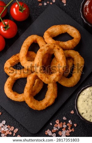 Deep fried breaded onion or squid rings, crispy fast food snacks. Fried onion or squid rings as a food background for your design.