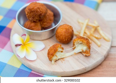 Deep Fried Cheese Ball And French Fries On Wood Dish