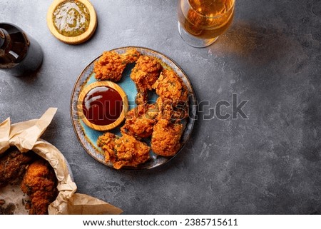 Deep fried chicken wings with bbq souse and beer on gray table top view copy space for text. High quality photo