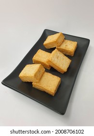 Deep fried Japanese Tofu in black plate, isolated in white background.