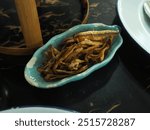 Deep fried small fish serving in the plate. Traditional snack in Thai restaurant. 