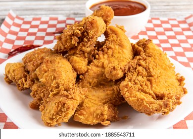 deep fried southern style breaded chicken tenders or chicken fingers on a white plate with dipping sauce - Shutterstock ID 1885543711