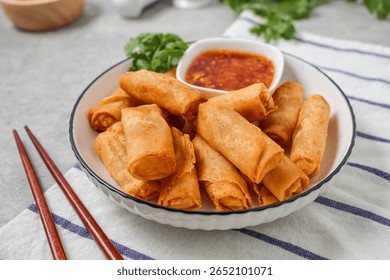 Deep fried vegetable spring rolls or egg rolls and sauce , Thai called popia in white  plate on grey background	