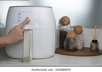 Deep fryer machine in modern home kitchen. The hand that adjusts the fryer machine. - Shutterstock ID 2245084593