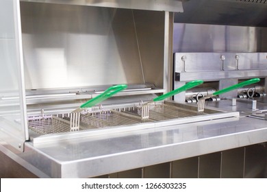 Deep Fryer For Potatoes And Nuggets. New Clean Empty Kitchen. Equipment Made Of Food Stainless Steel. Baskets For Fryer. Concept Fast Food Restaurant