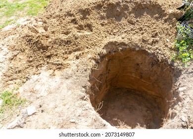 A Deep Hole Is Dug In The Ground, A Funeral, Earthworks, Soil Development During Construction Work, A Sinkhole In The Ground