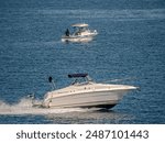 Deep Hulled Speedster Passing Fishing Boat