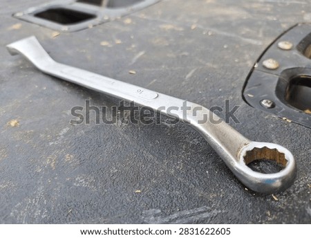 Deep offset double end ring spanner 16mm on black toolbox surface, 12 point box end wrench designed to reach recessed fasteners close up detail.