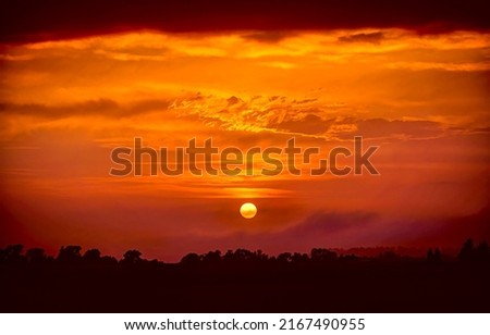 Deep orange sundown in sky at sunset. Sundown silhouette in sunset sky