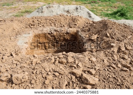 Deep pit in the ground. Digging a hole. Big bottomless hole in the ground