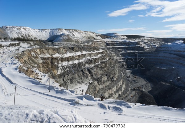 deep pit on\
the background of a snow-covered\
field