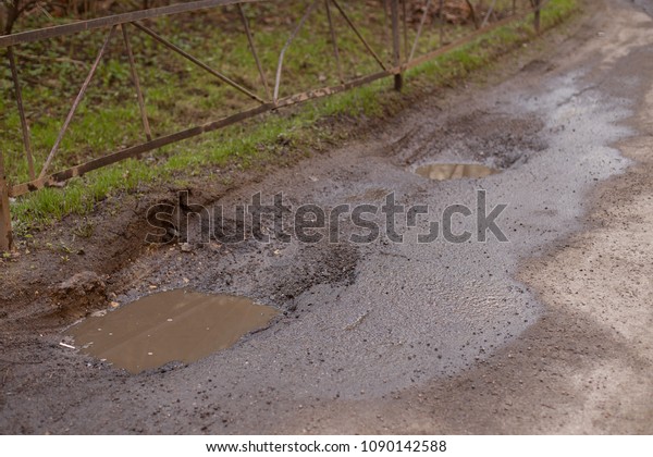 deep pit and puddle on the\
road