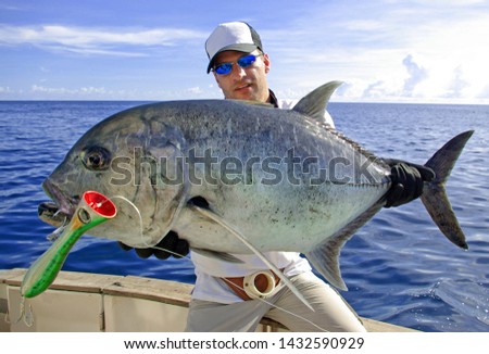 Deep sea fishing. 
Catch of fish. Big game fishing, boat fishing, lure fishing, Fisherman holding a big Trevally jack
