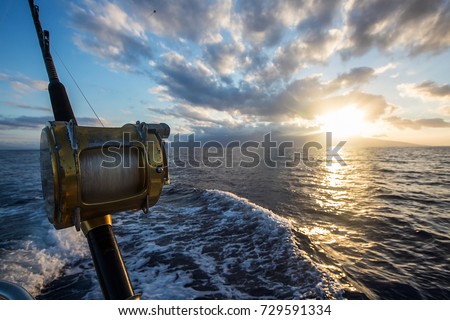 Deep Sea Fishing Reel on a boat during sunrise 