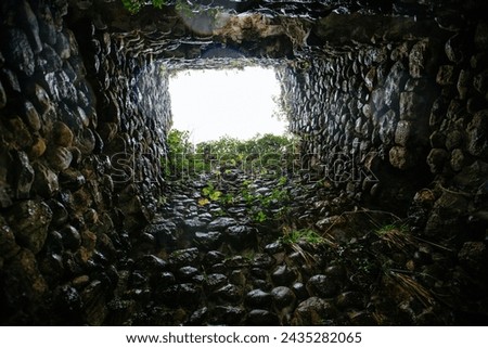 Deep stone well or old stone tower. View from bottom.