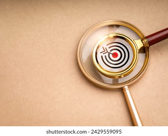 Deep target and trends, research and finding for detail to right goal, digital niche marketing concepts. Big target icon in small magnifying glass stack on big magnifier on recycle paper background.