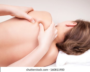 Deep tissue massage on a woman's  shoulder blade  - Powered by Shutterstock