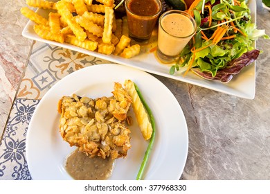 deep-fried fish steaks with almond flakes on dish - Powered by Shutterstock