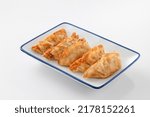 Deep-fried gyoza in a plate on white background.