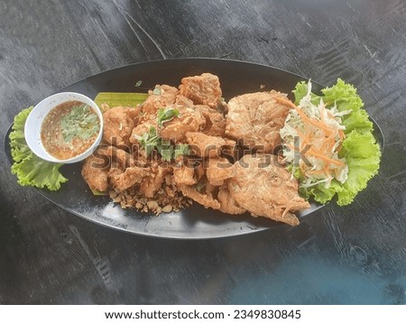 Deep-fried Red Ruby Fish: Turn the fish into pieces and fry in oil in a hot pan until the fish remains crispy. Put the fish on a plate and decorate with vegetables. There is chili sauce with salted fi
