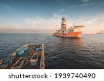 Deepwater drilling ship in operational condition seen at oil field with supply boat in stand by for cargo operation.