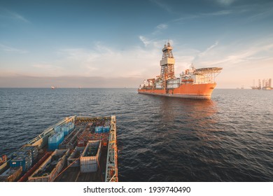Deepwater drilling ship in operational condition seen at oil field with supply boat in stand by for cargo operation.