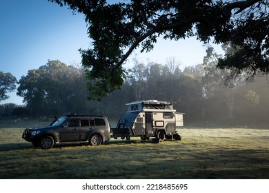 DEEPWATER, NSW, Australia, 20.03.2022: Car And Camper Trailer Parked Under Trees In Beautiful Morning Light