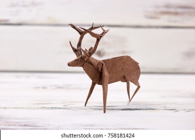 Deer figurine on wooden background. Beautiful handmade art, origami or paper folding. Crafts and creative skills. - Powered by Shutterstock - Get 15% off with code: PIKWIZARD15