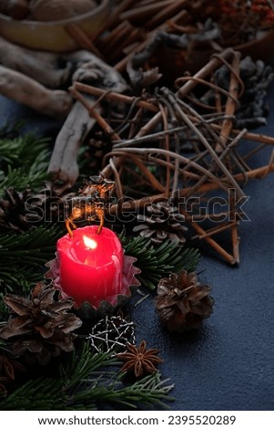 deer and pentacle star amulets, burning candle, cones, fir branches on dark abstract background. Witchcraft, Esoteric magical Ritual for Yule, Winter Solstice wiccan holiday.