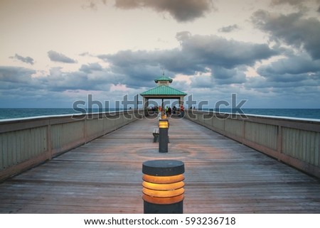Deerfield Beach, Florida Pier Boardwalk Facing East Toward Atlantic Ocean After Dusk with Lights Illuminated, a Few People Fishing and a Layer of Gray Clouds Above through Brown Graduated Filter